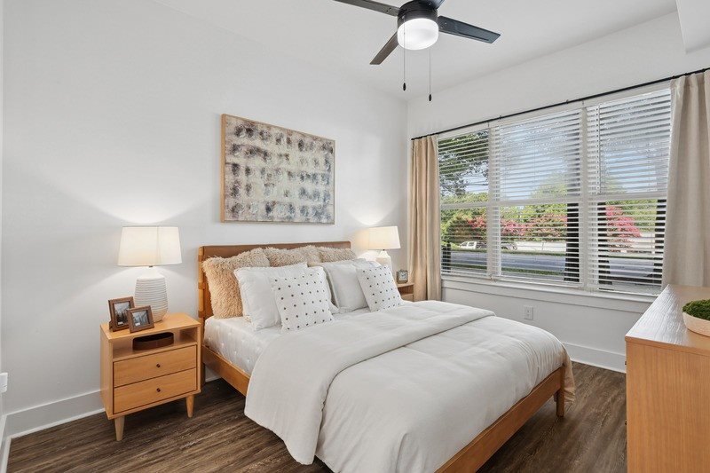 A bedroom with a bed, nightstand, and a ceiling fan.