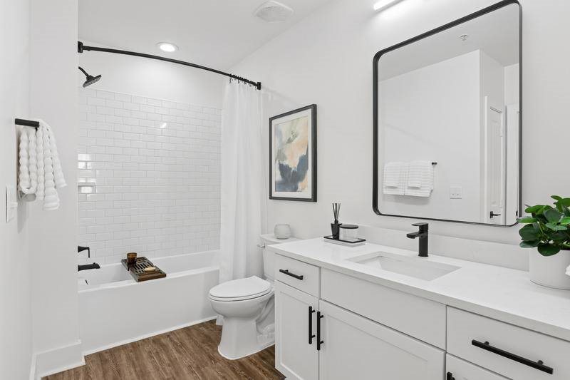 A white bathroom with a toilet, sink, and mirror.