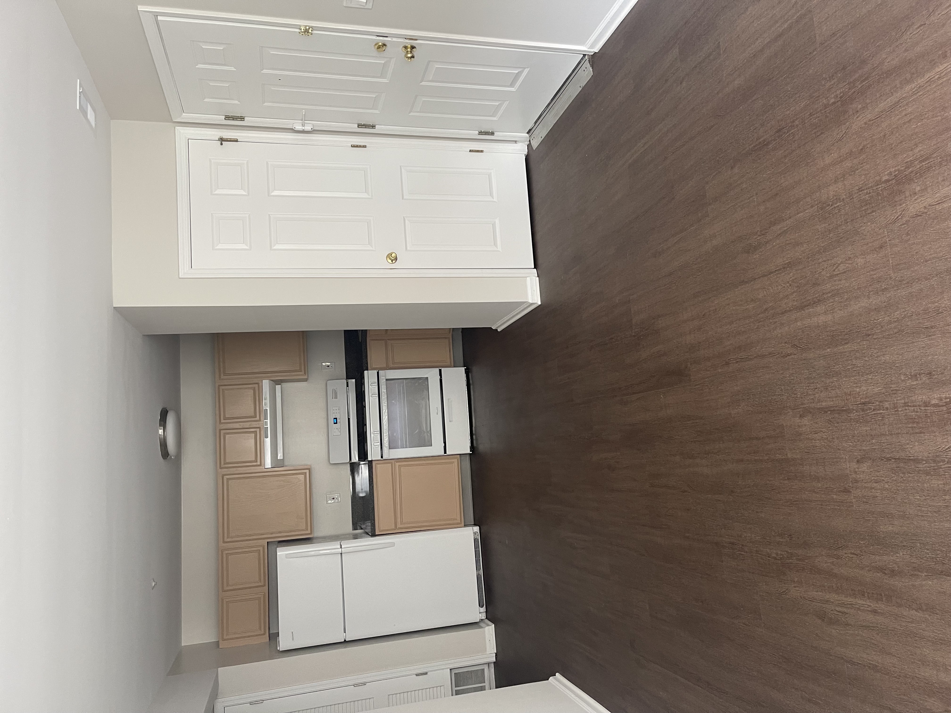A kitchen with brown walls and white cabinets.