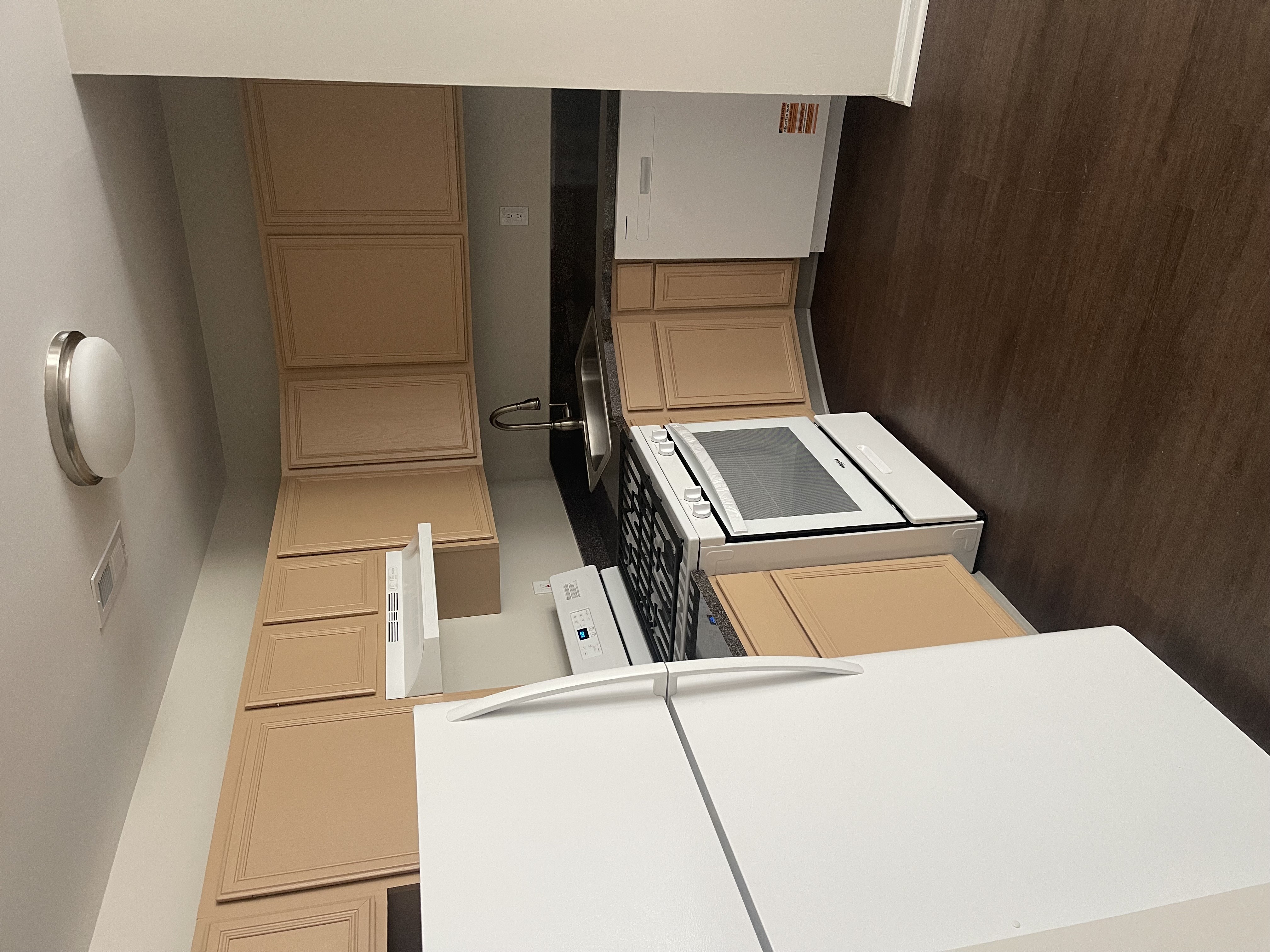 A white refrigerator is in a kitchen with wooden cabinets.