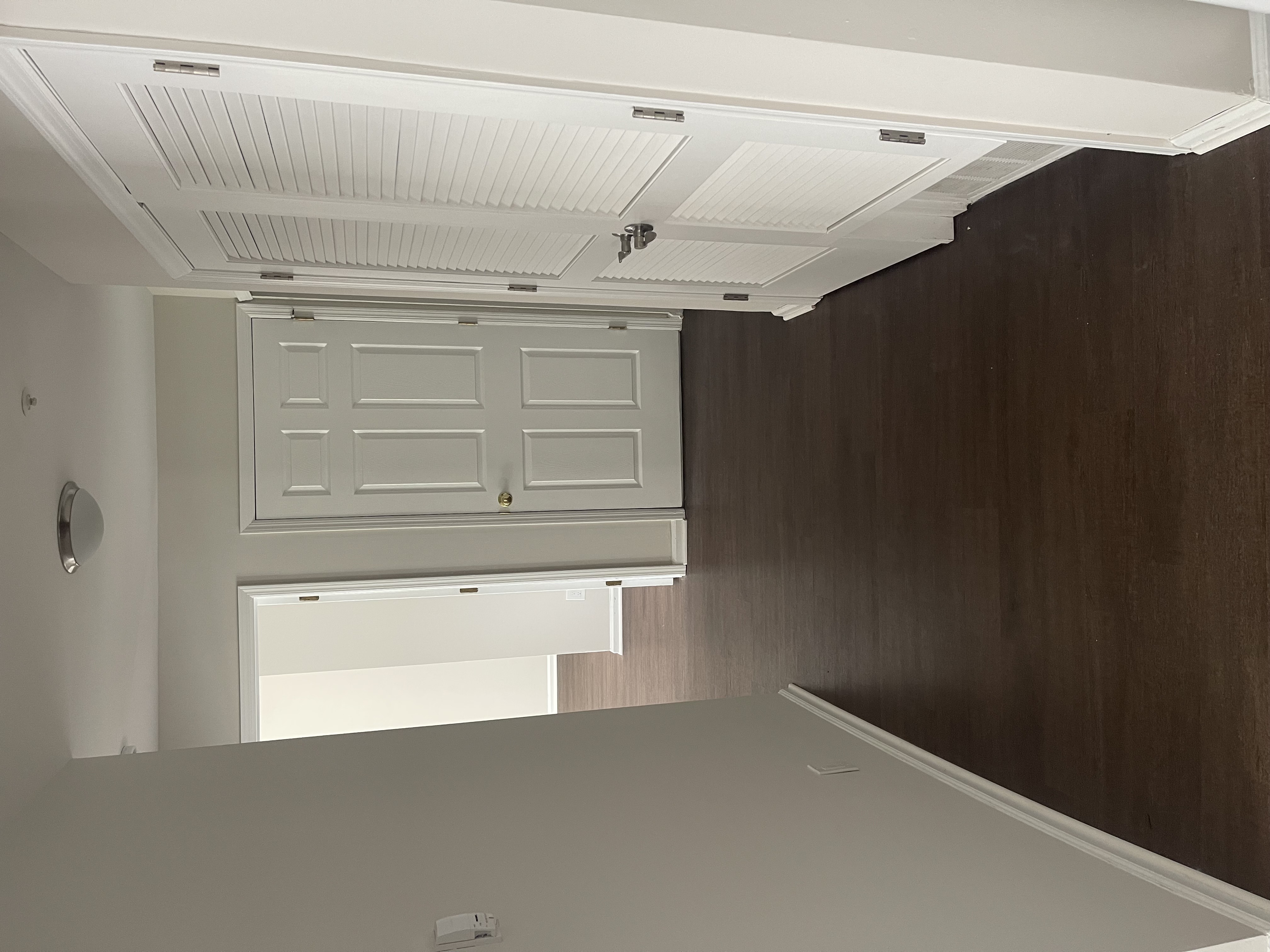 A white door with a white frame is in a room with a brown wall.