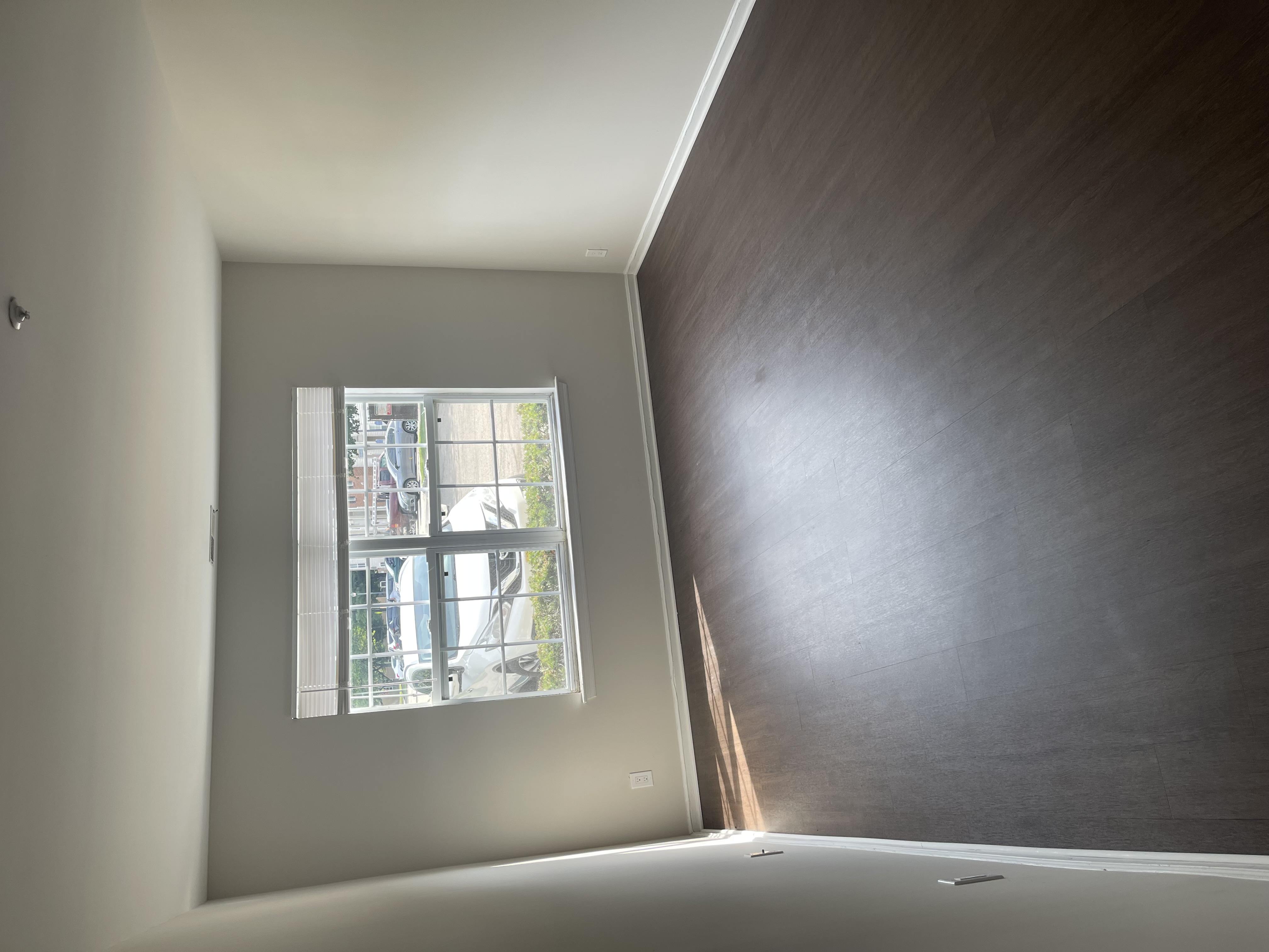 A room with a window and a wooden wall.