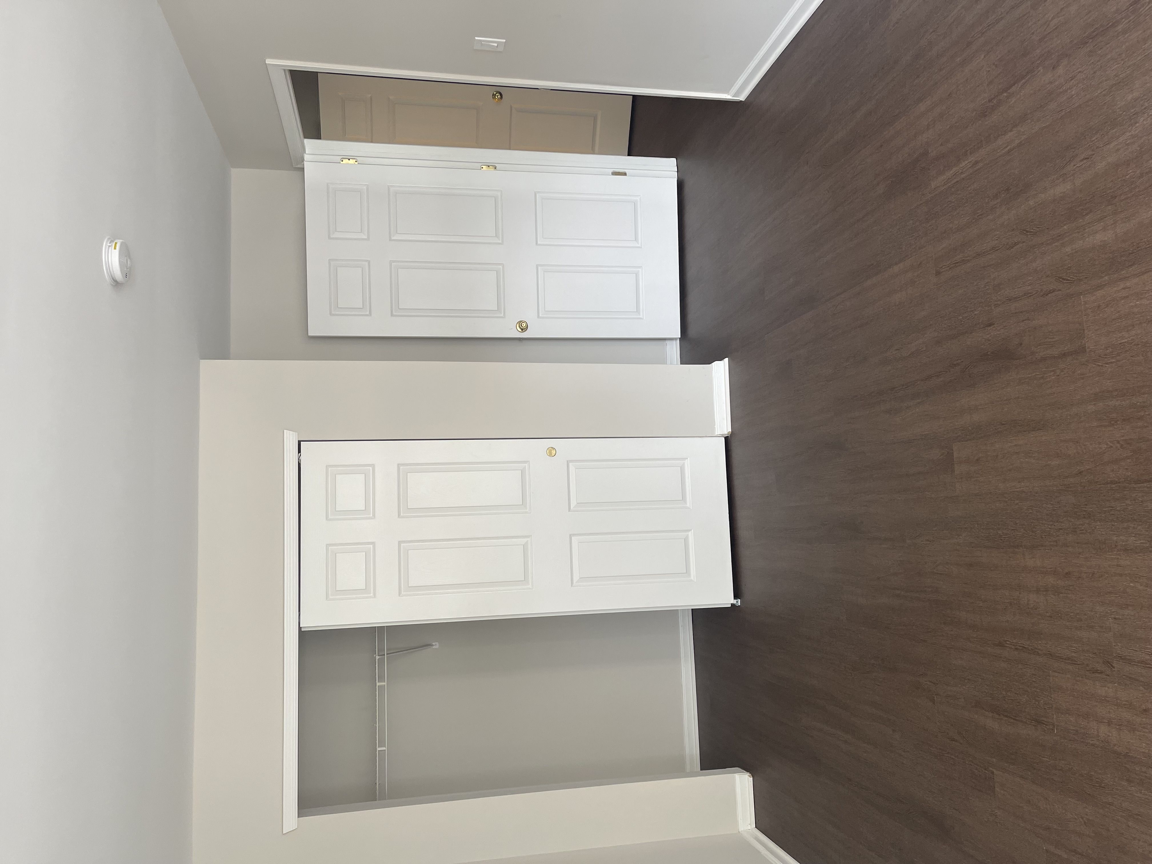 A white cabinet with a shelf is mounted on a wall.