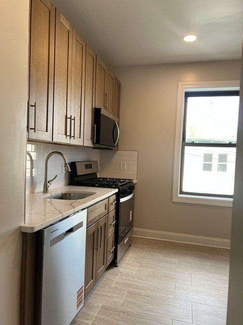 A kitchen with wooden cabinets and a window.