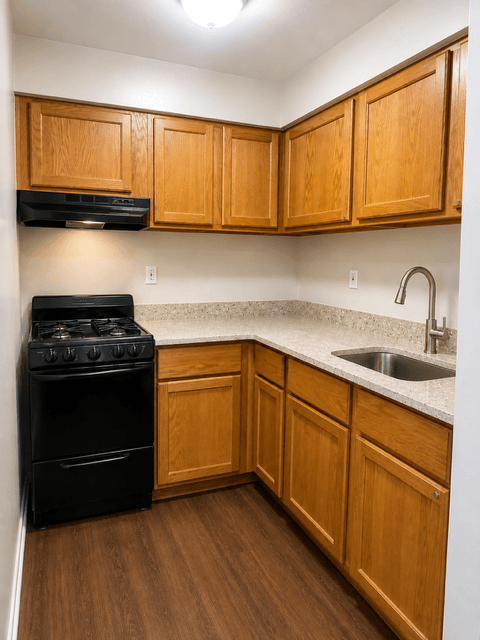A kitchen with wooden cabinets and a black stove top oven.