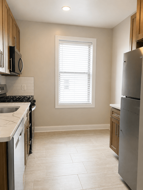 A kitchen with a stove, sink, and refrigerator.