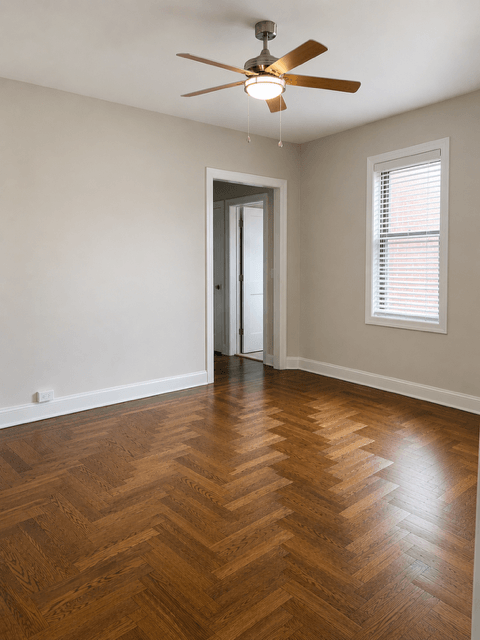 A room with a wooden floor and a ceiling fan.