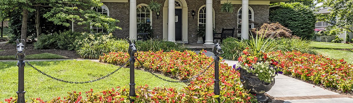 a house with a lawn and flowers in front of it