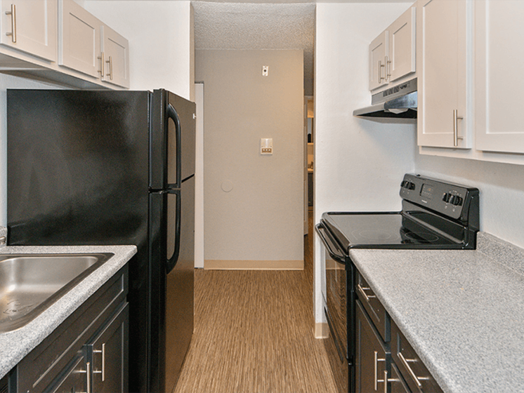 Apartments Federal Way, WA - Kitchen with Black Appliances, Black Lower Cabinets, and Light Upper Cabinets