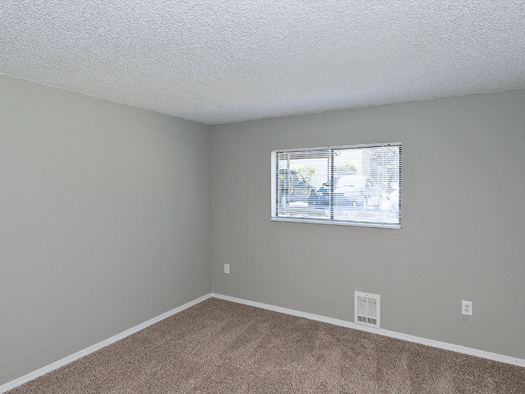 Two-Bedroom Apartments in Federal Way, WA - Spacious Bedroom with Plush Carpet, a Window, and Neutral Colored Walls