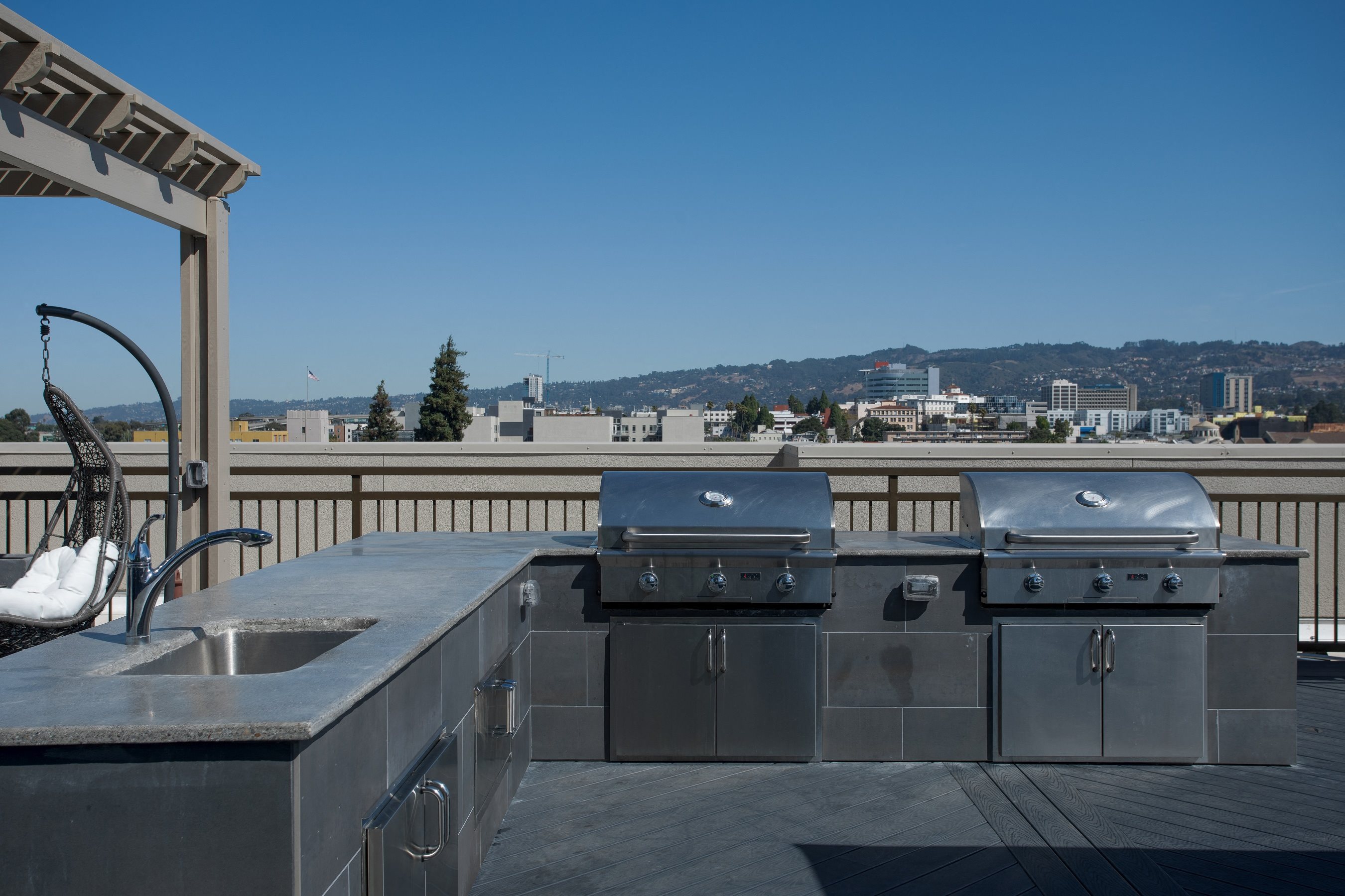 Oakland CA Apartments for Rent - Expansive Rooftop with a Great View of the City Featuring Various Shaded Lounging Areas and Outdoor Grill