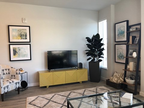 Apartments in Oakland for Rent - Rasa - Living Area with Windows, White Walls, and Wood Flooring