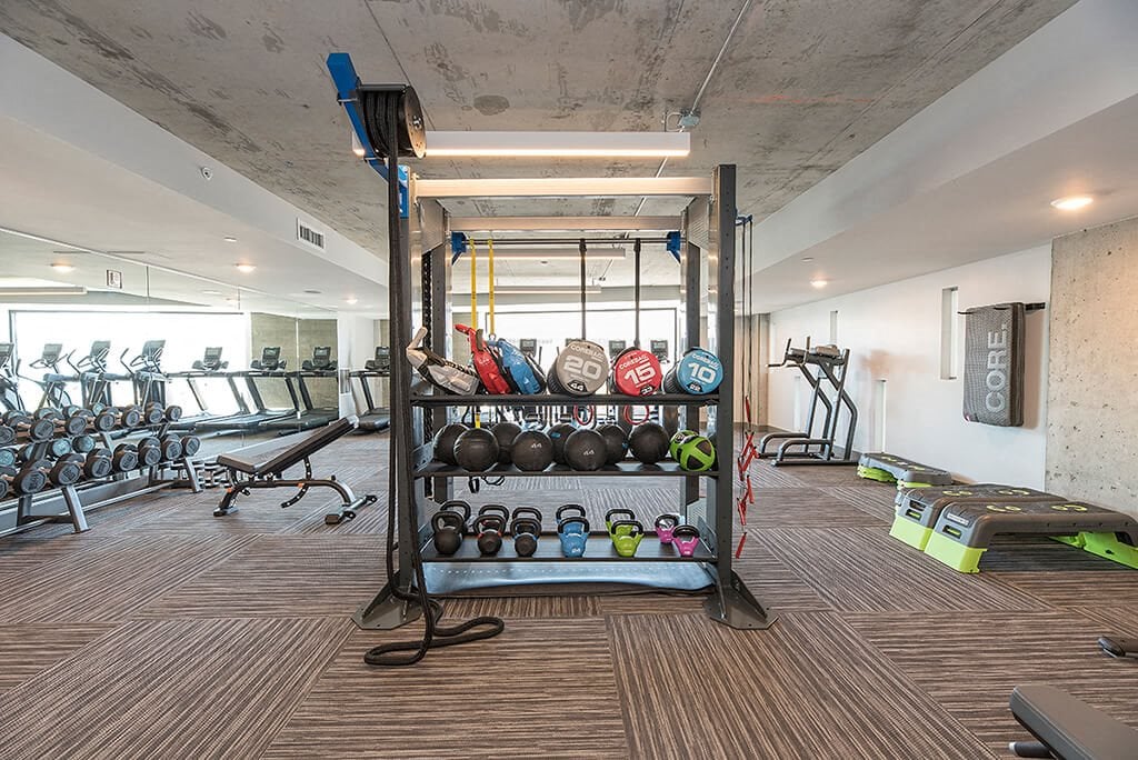Gym with weighs l Orion Apartments in Oakland