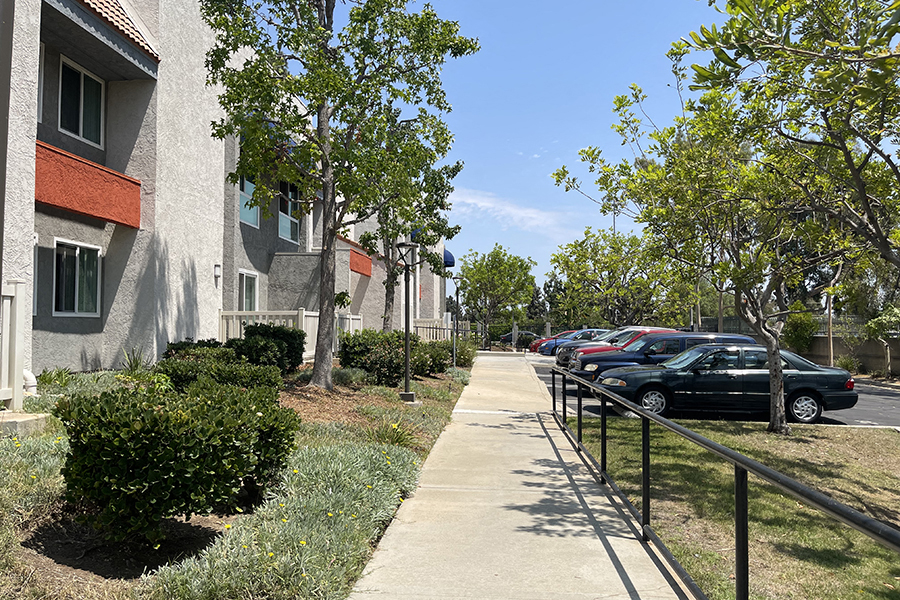 Sidewalk next to buildings and parking