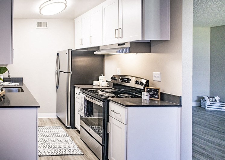 Apartments for Rent in Rocklin - Kitchen with Stainless Steel Appliance, Wood Flooring, and White Cabinets.