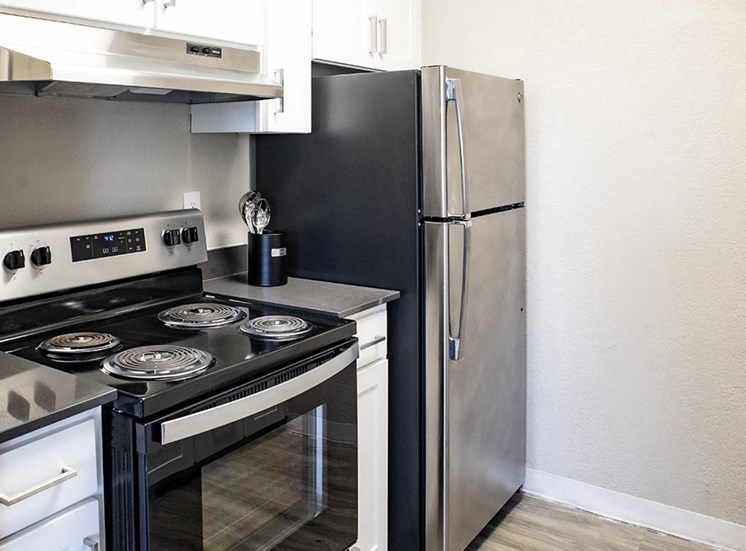 Apartments for Rent in Rocklin CA - The Everette - Kitchen with Stainless Steel Appliances, Grey Countertops, and White Cabinets