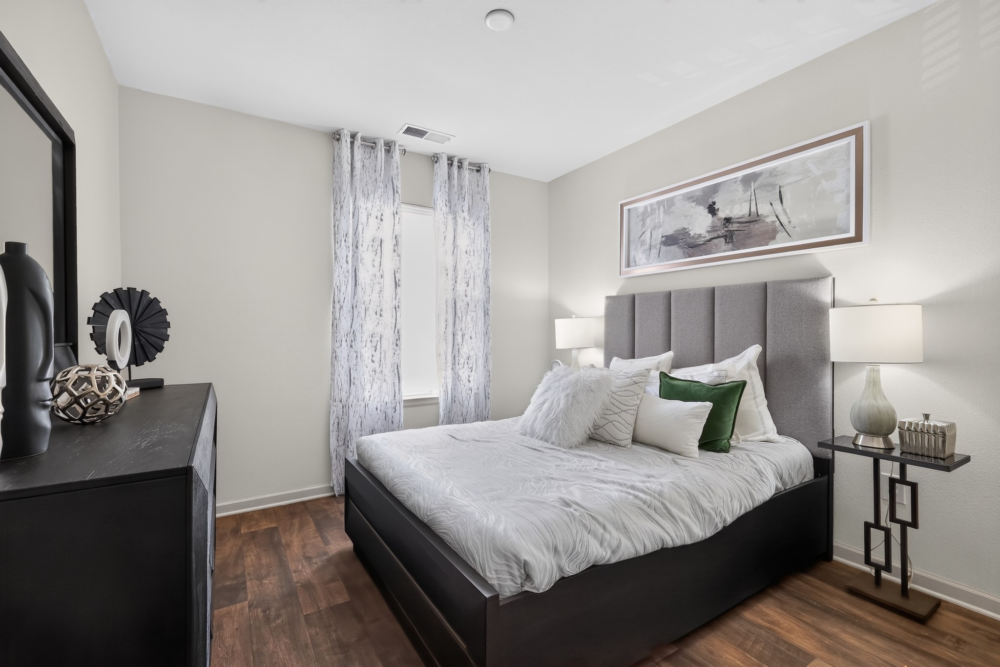 A bedroom with a large bed and a mirror on the wall.