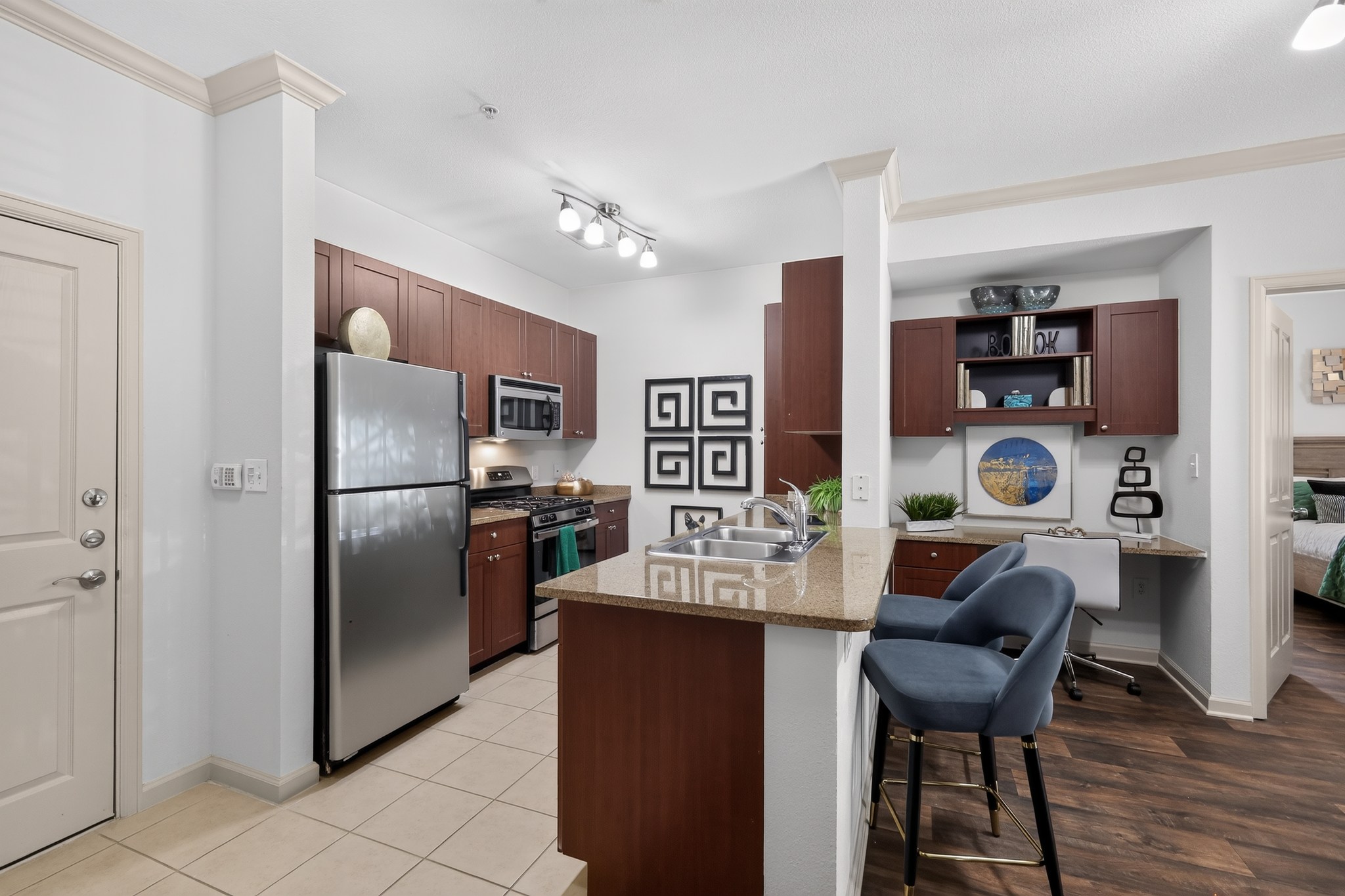 A kitchen with a refrigerator, cabinets, and a counter.
