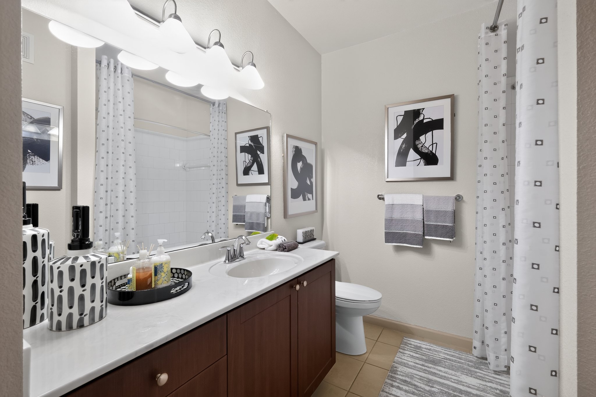 A bathroom with a white sink and brown cabinetry.
