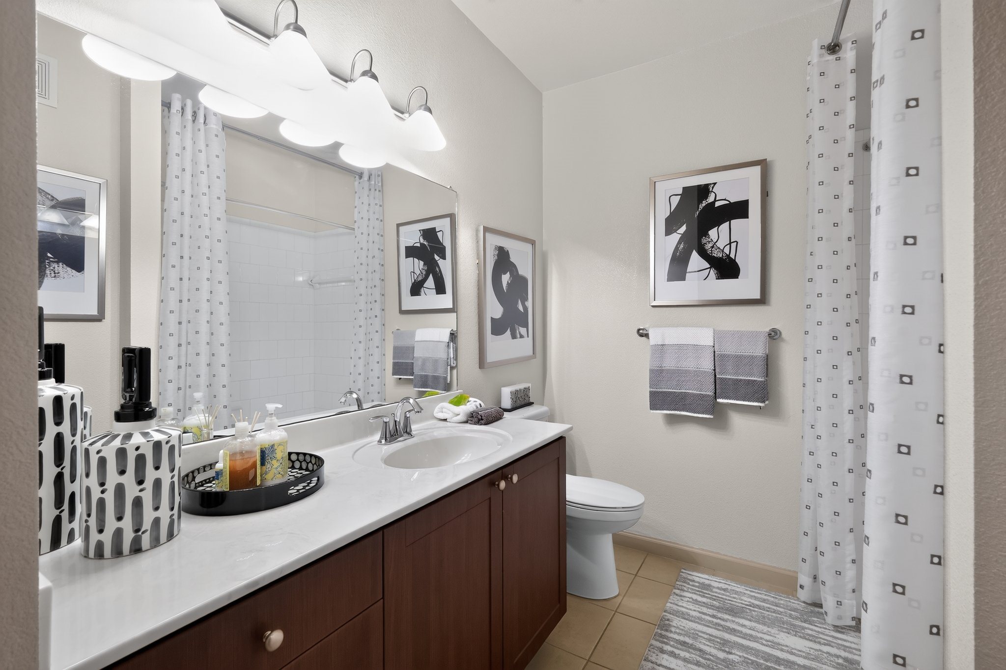 A bathroom with a white sink and brown cabinetry.