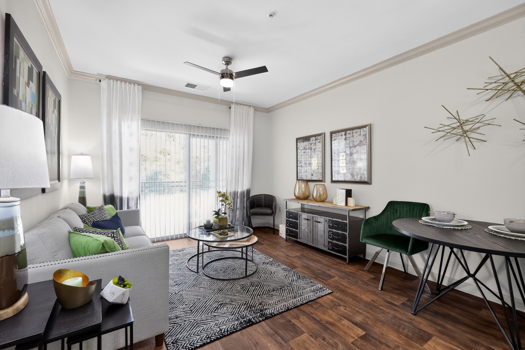 A living room with a grey couch, a black coffee table, and a green chair.