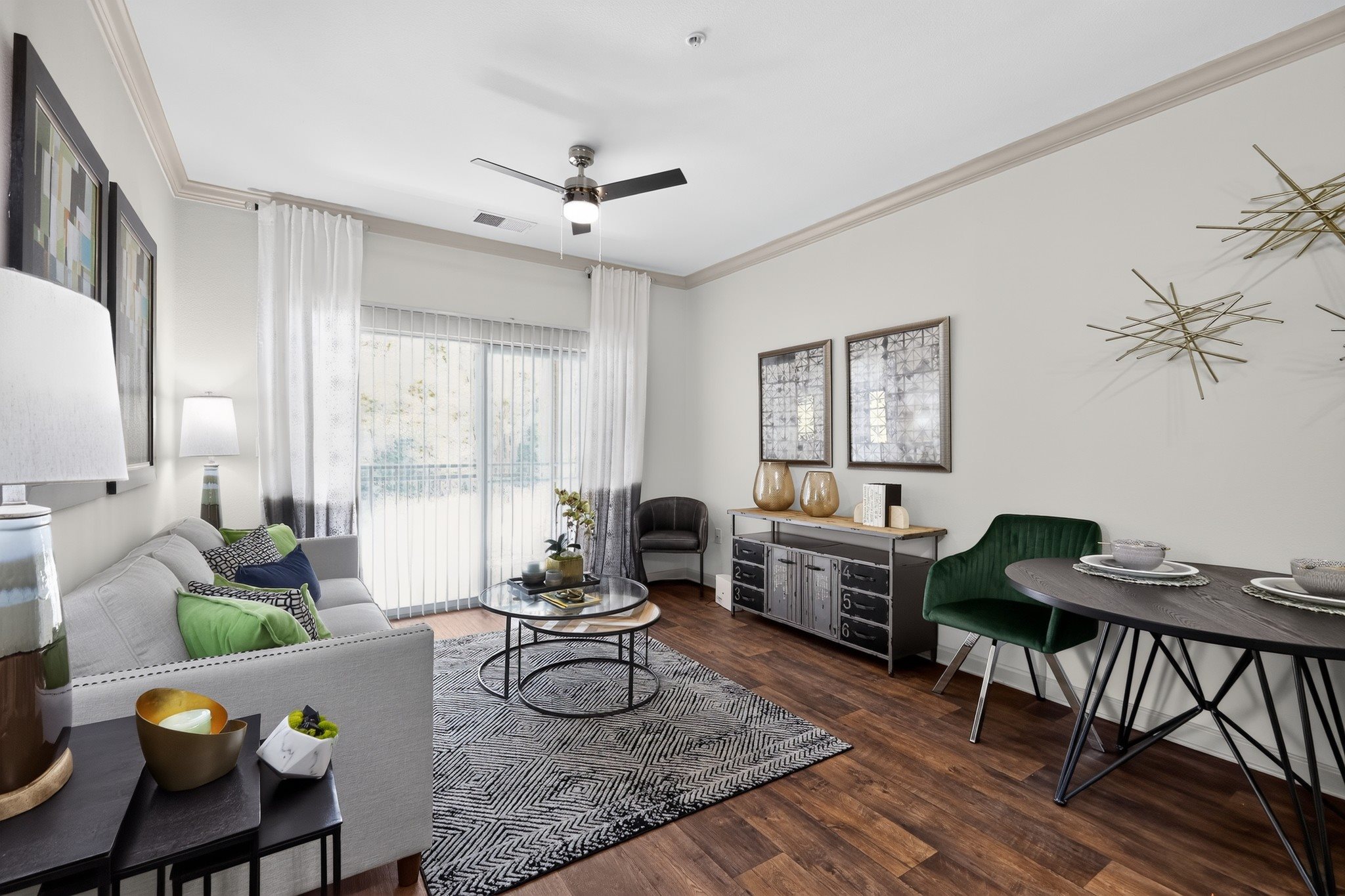 A living room with a grey couch, a black coffee table, and a green chair.