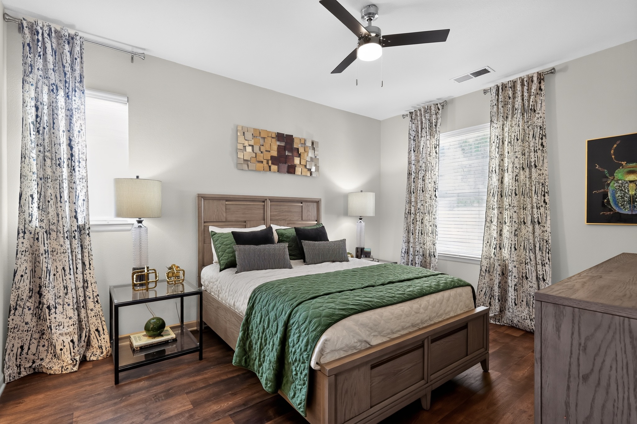 A bedroom with a bed, nightstand, and a ceiling fan.