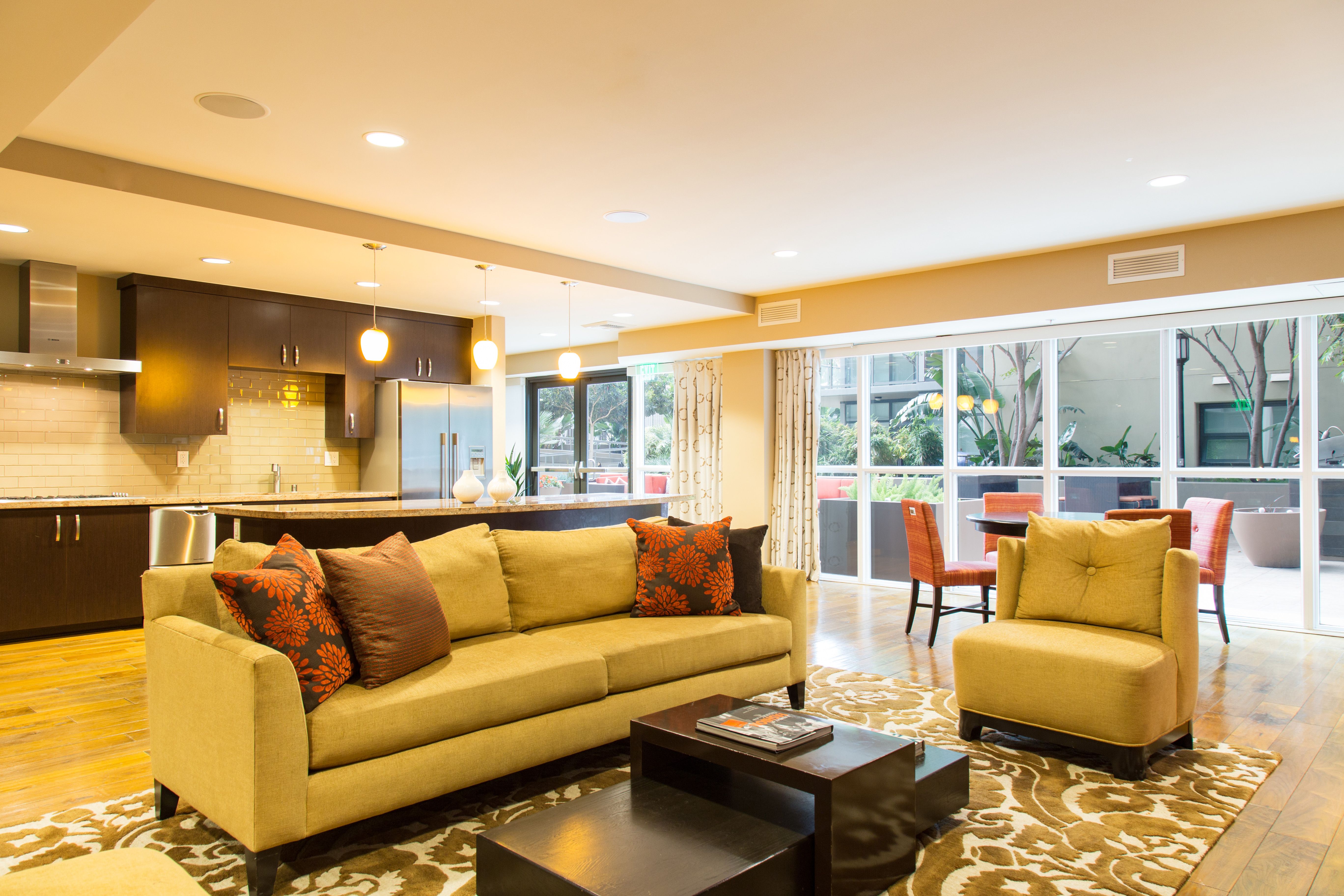 A living room with a yellow couch and a coffee table.