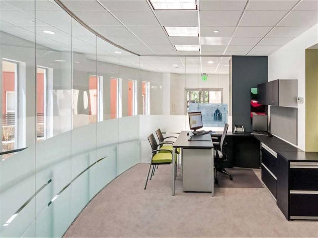 A glass wall separates the office from the hallway.