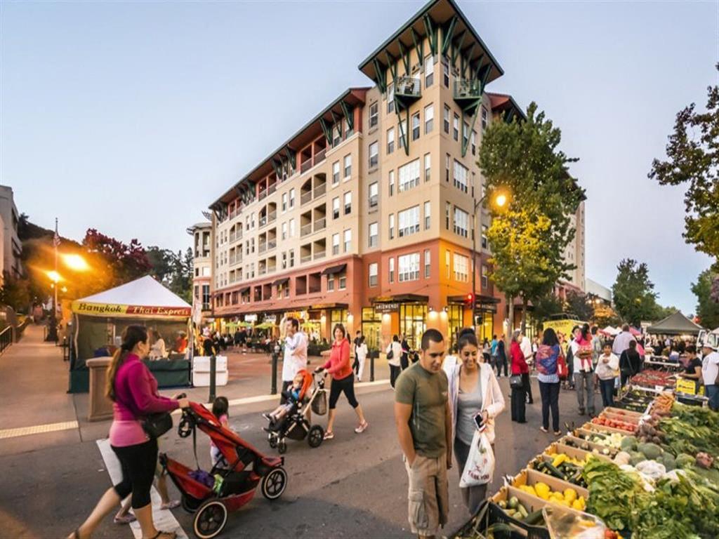 A street market is bustling with people shopping for fresh produce.