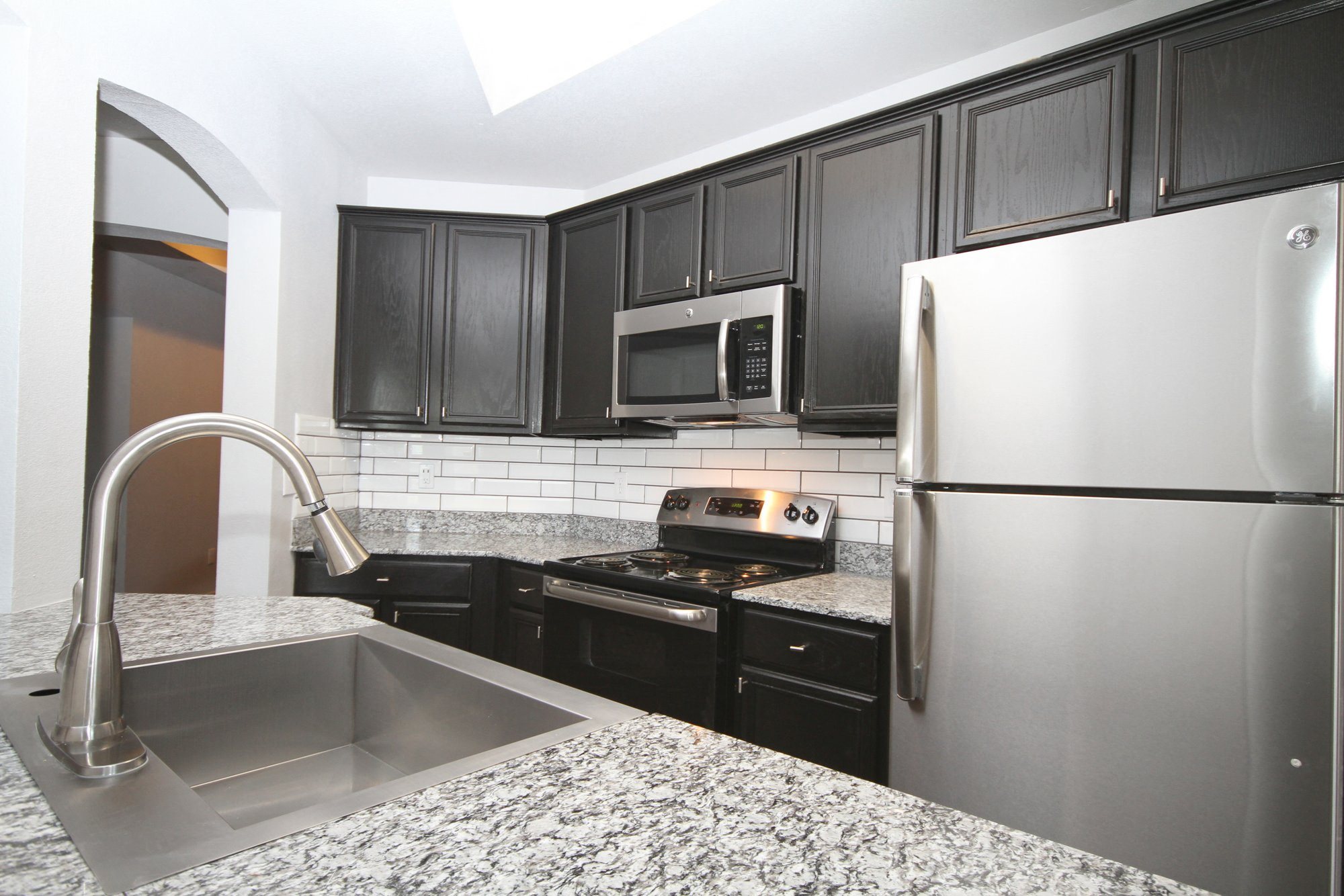 Apartments for Rent in San Antonio - Gorgeous Kitchen with Black Cabinets, Designer Backsplash, and Stainless Steel Appliances
