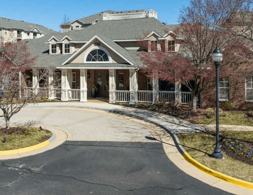 Exterior view of a clubhouse with a covered porch and circular driveway.