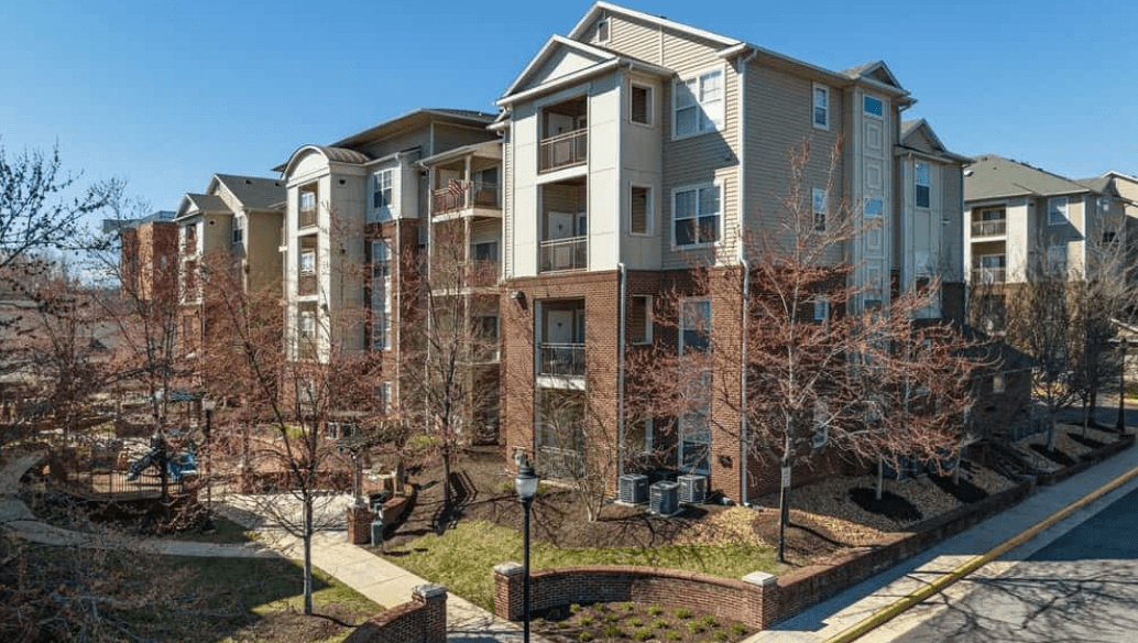 Exterior view of a modern apartment building complex with balconies and a playground.