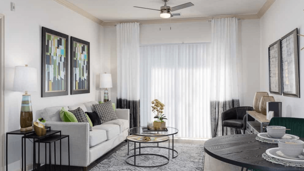 Modern living room with sofa, round tables, and dining area.