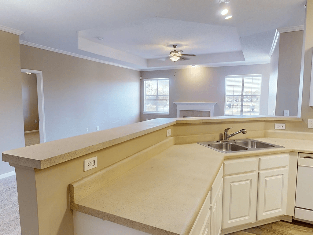 a kitchen with a sink and a ceiling fan