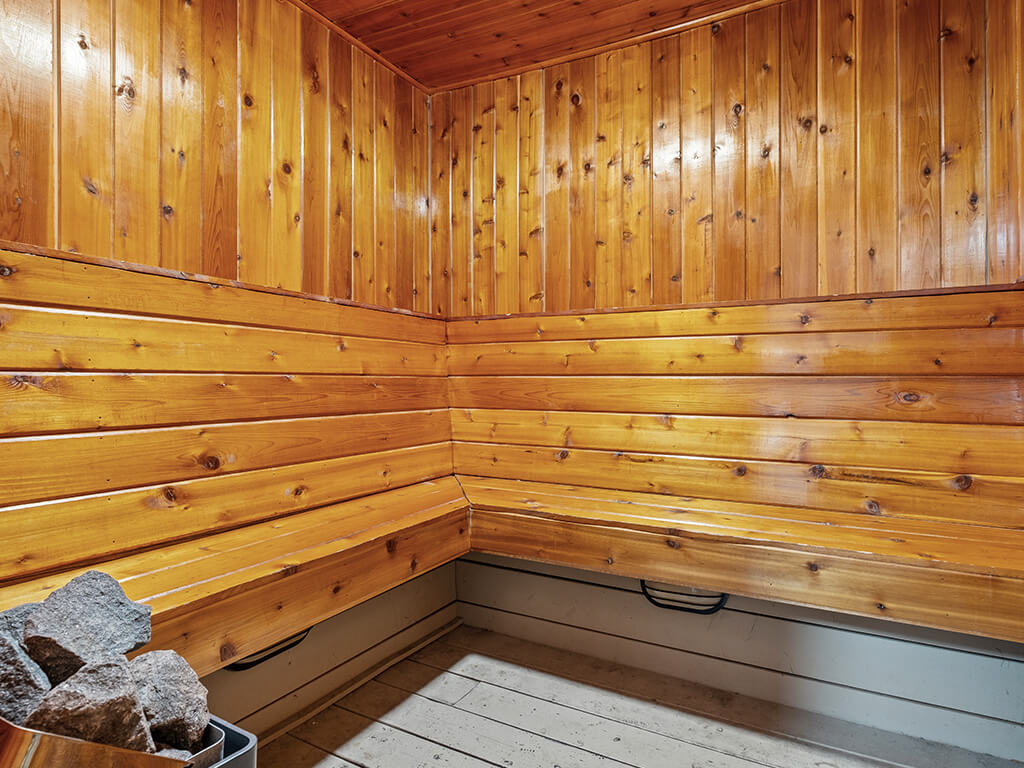A wooden sauna with a bench at apartment complex