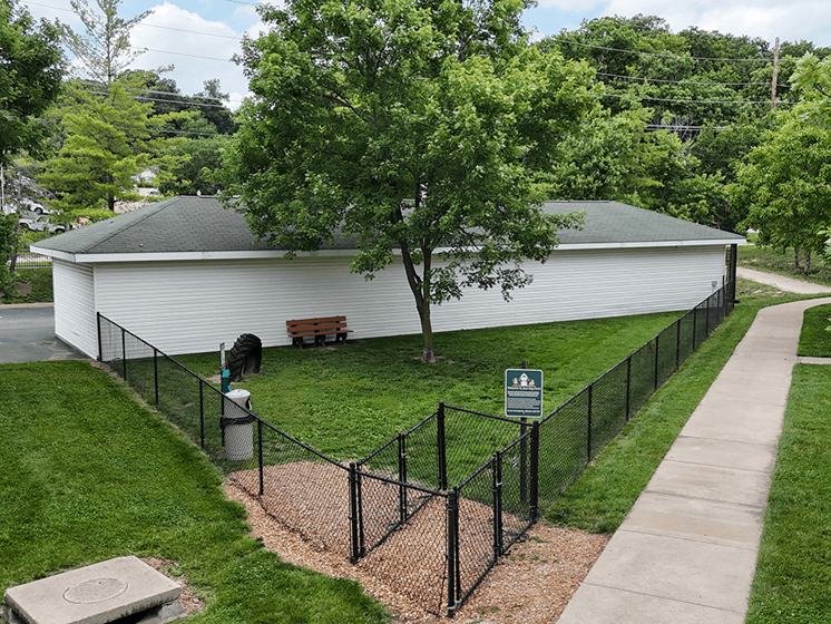 A white building with a black fenced dog park in front of it.
