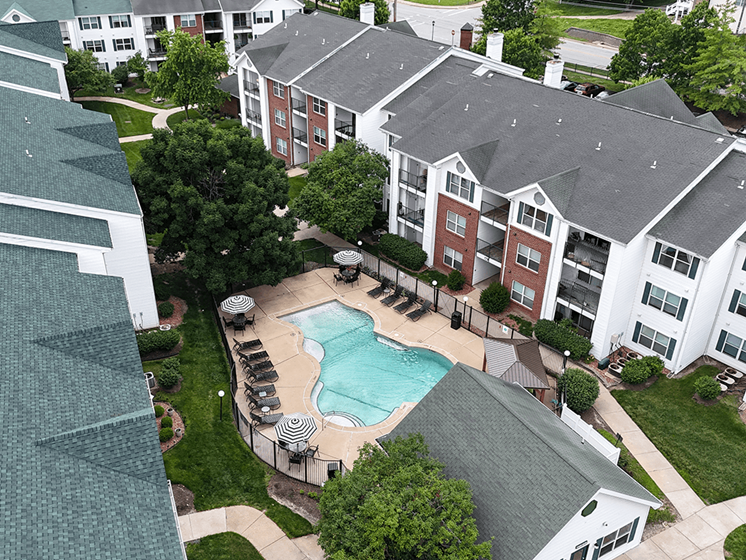 A large apartment complex with a pool in the middle.