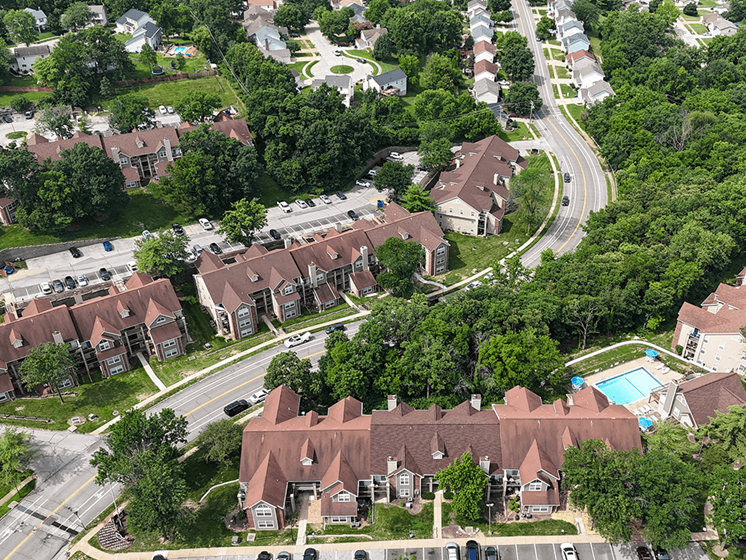 A bird's eye view of a residential area with houses and a swimming pool.
