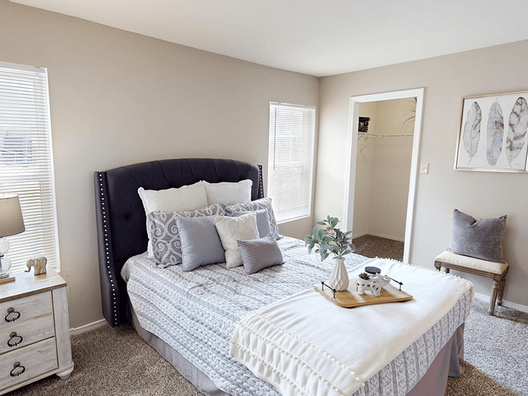 A bedroom with a large bed and a nightstand with a lamp.