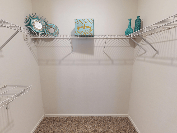 A white shelf with a few decorative items on it.