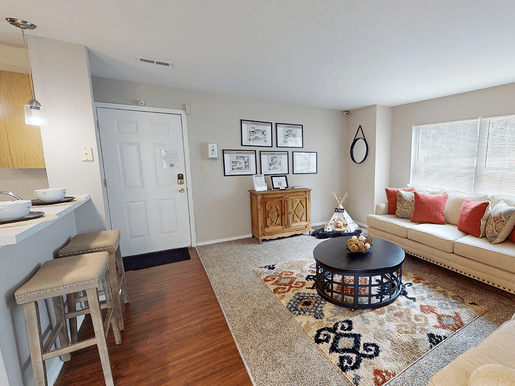 A living room with a white sofa, a coffee table, and a rug.