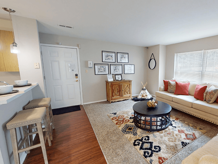 A living room with a white sofa, a coffee table, and a rug.