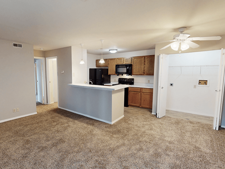 A kitchen with a white counter and a black fridge.