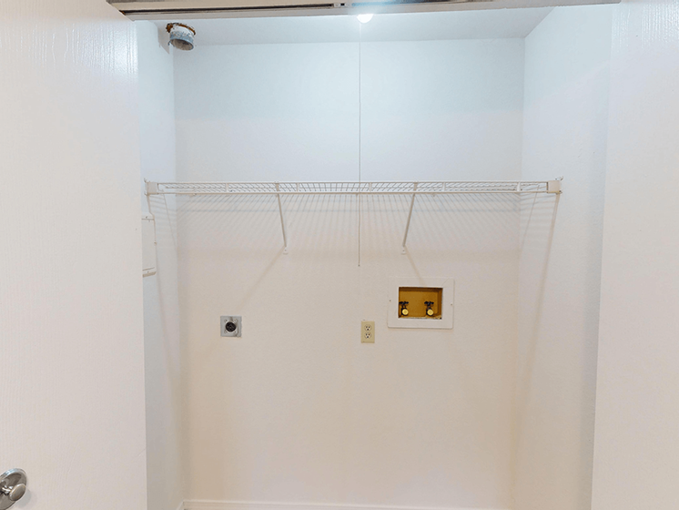 Interior of laundry space with washer and dryer connections.