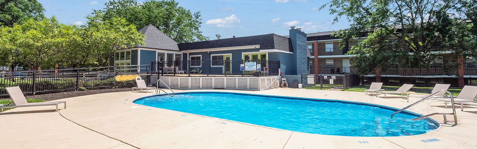 A small pool with a deck and sun loungers.
