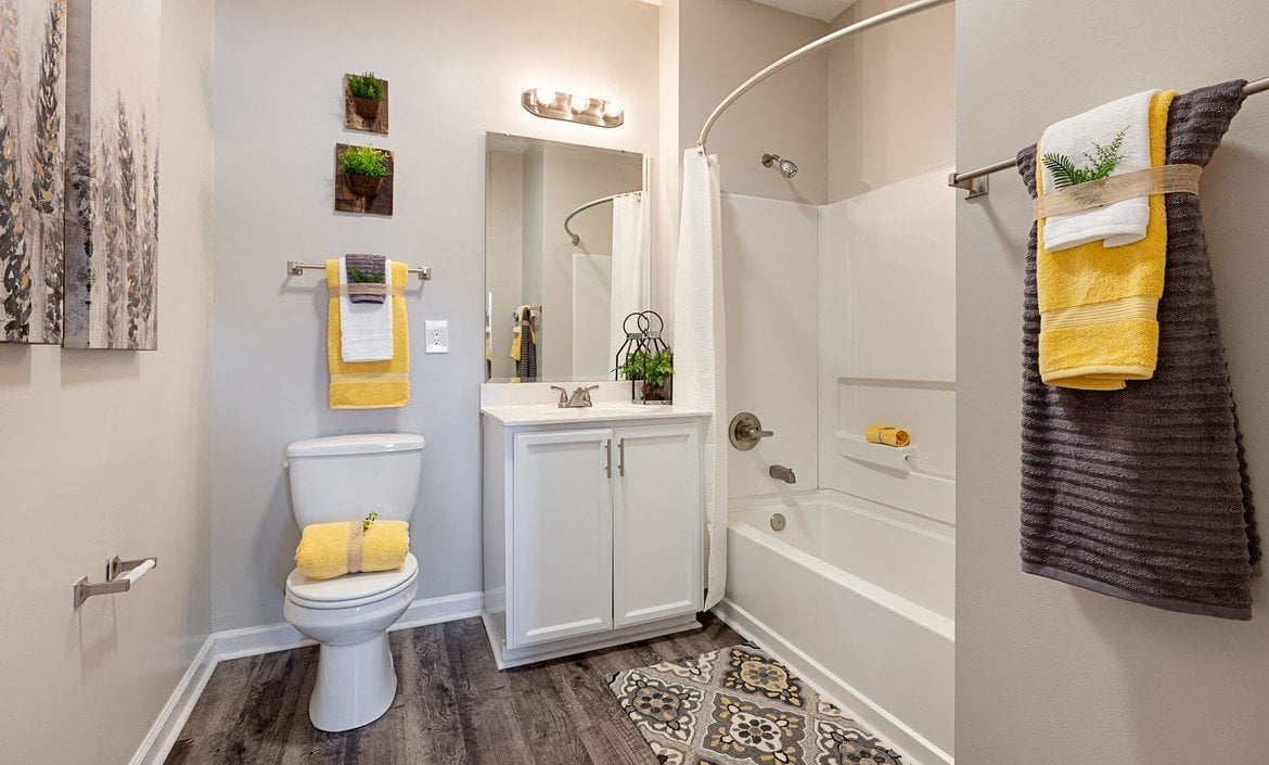 Spacious bathroom with vinyl flooring, white storage cabinets and soaking tub at The Summit on 401.