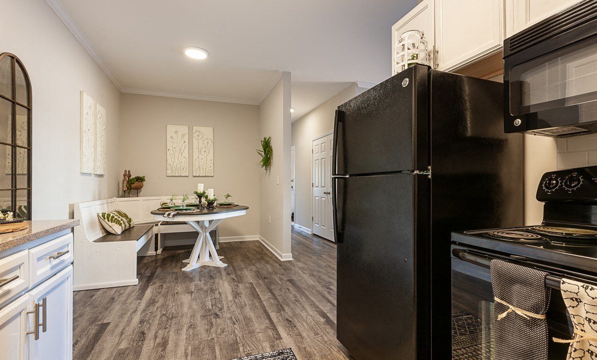 Spacious kitchen with white cabinetry and black energy efficient appliances at The Summit on 401 in Fayetteville, NC