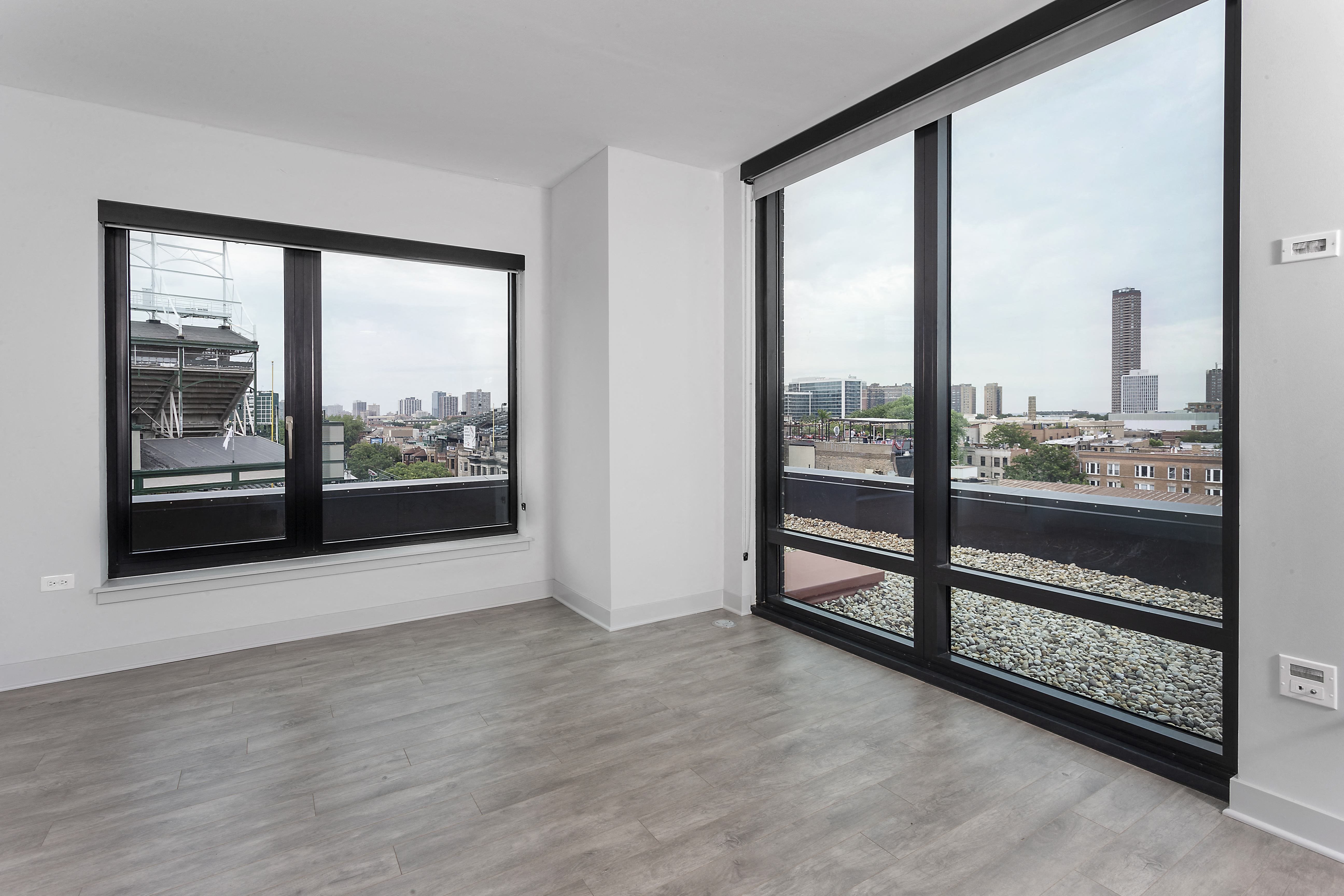 a living room with large windows and a view of the city at Residences at Addison Clark Apartments, Chicago, 60613