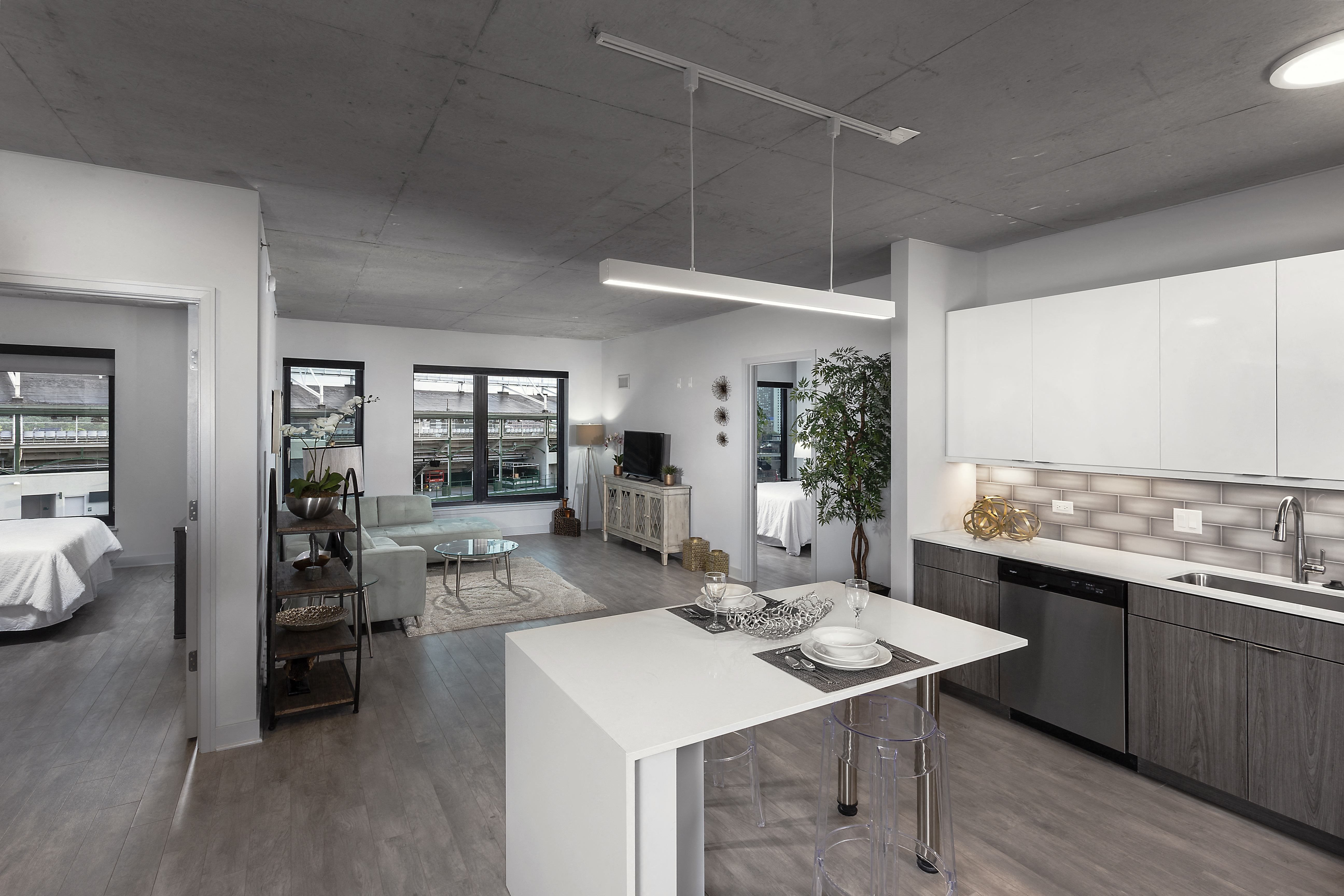 a kitchen and living room with a white island in the middle at Residences at Addison Clark Apartments, Chicago, 60613